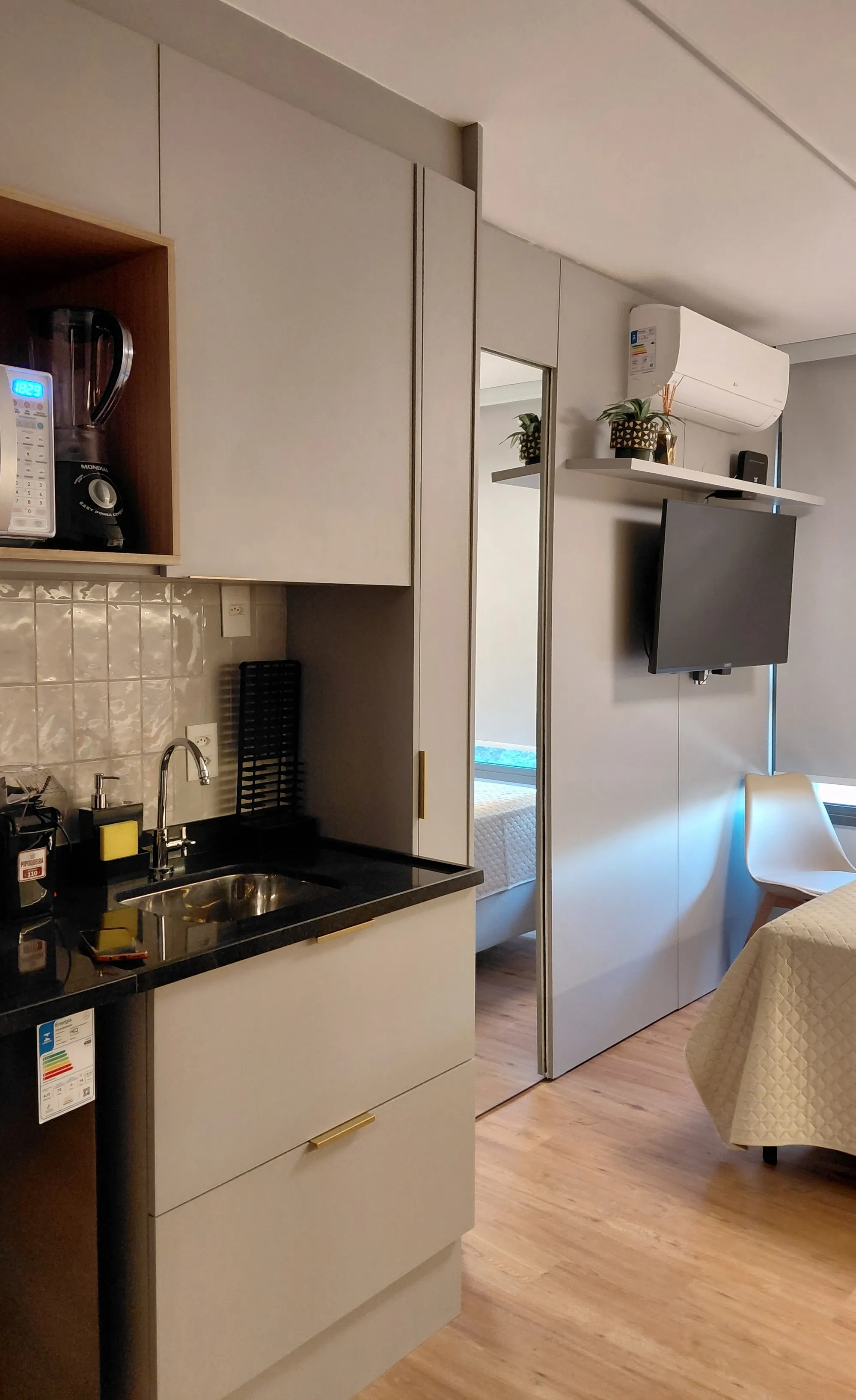 Vista da cozinha compacta com marcenaria cinza e bancada preta